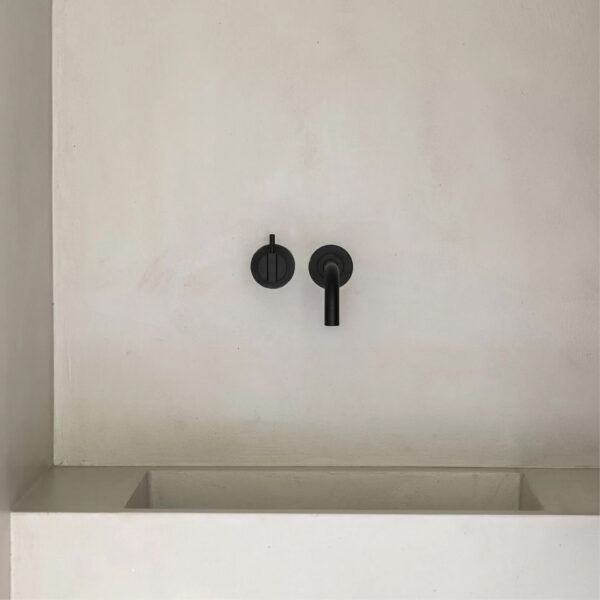 Tvättställsblandare i svart inbyggd i vägg.